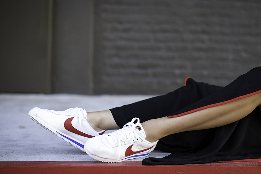 Detail shot of Liv wearing Nike Cortez, Forever 21 black red palazzo track pants