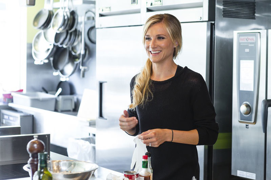 Brianne Theisen-Eaton smiling in a kitchen for the Liv For Luxury Cooking Contributor Series