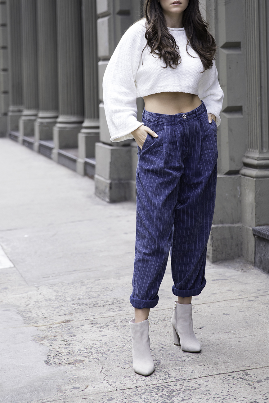 Liv Micheli standing in the streets of SoHo wearing OFF WHITE c/o Virgil Abloh x Warby Parker Medium sunglasses, Urban Outfitters Roll neck Cropped Sweater, Silence + Noise Relaxed-Fit trousers and Kenneth Cole boots.